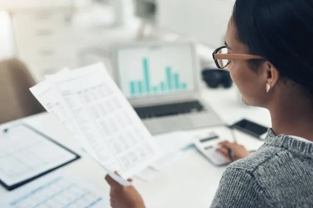 Woman reviewing tax paperwork and looking at charts